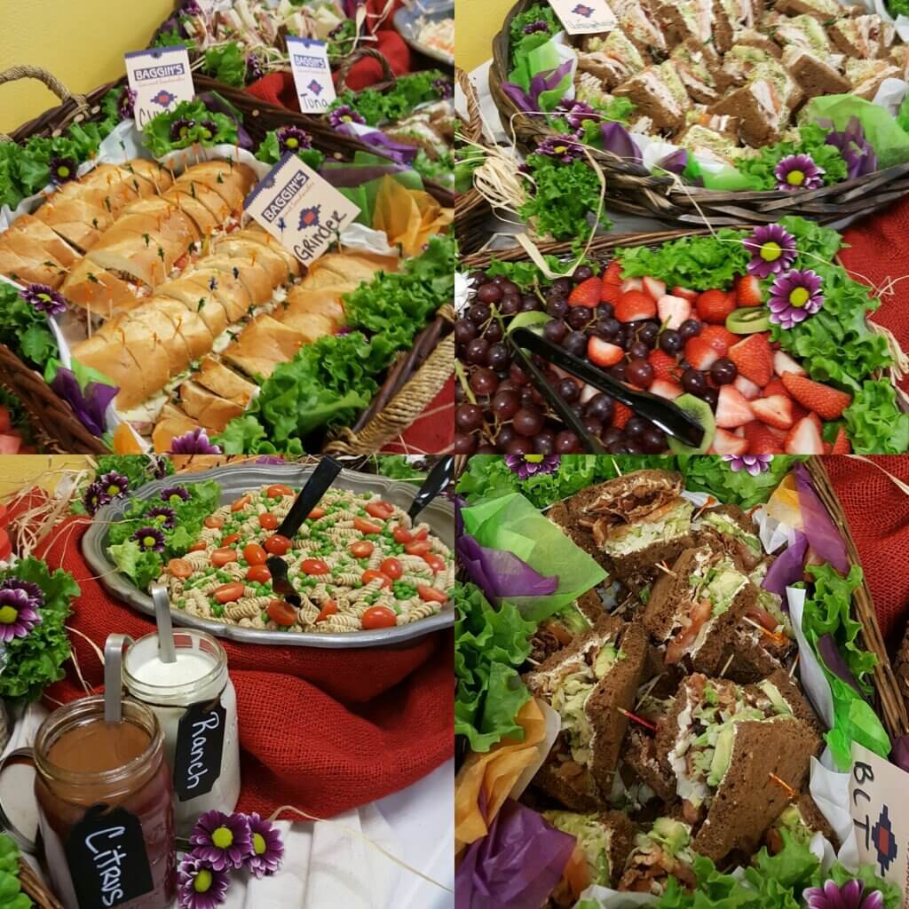Catering by Baggin's Gourmet with platters of gourmet sandwiches, fruits, and pasta salad neatly displayed on a banquet table