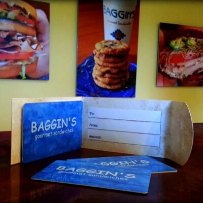 3 blue Baggin's Gourmet gift cards displayed on a table